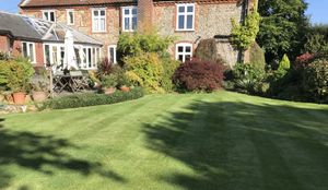 A house with well maintained lawn and shrubs in front
